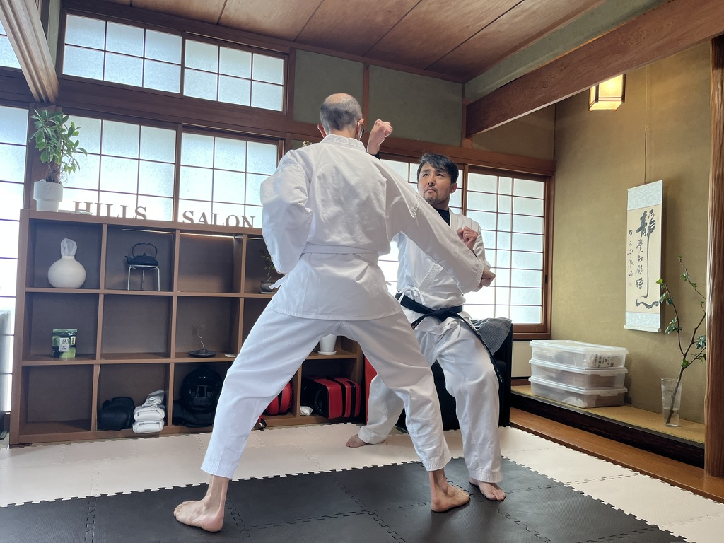 Hirokazu Inada Sensei and guest face each other in a traditional dojo